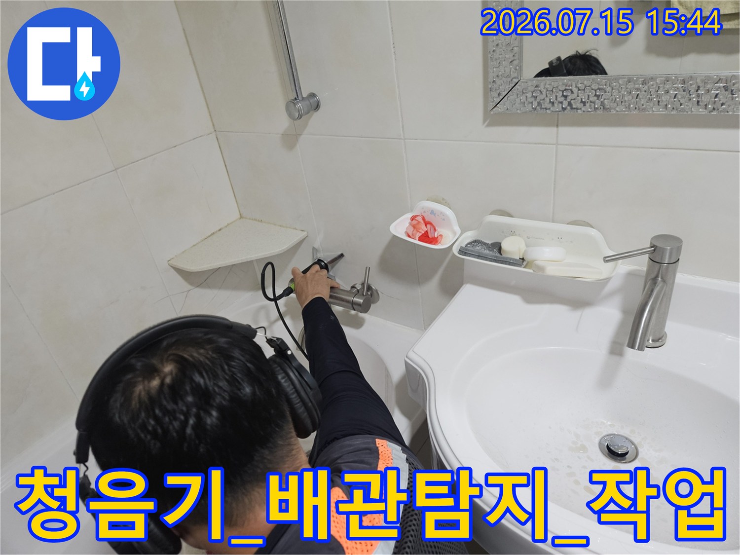 전문가용 청음식 탐지기를 사용하여 세면대 하부 배관의 누수 지점을 정밀하게 추적하는 모습