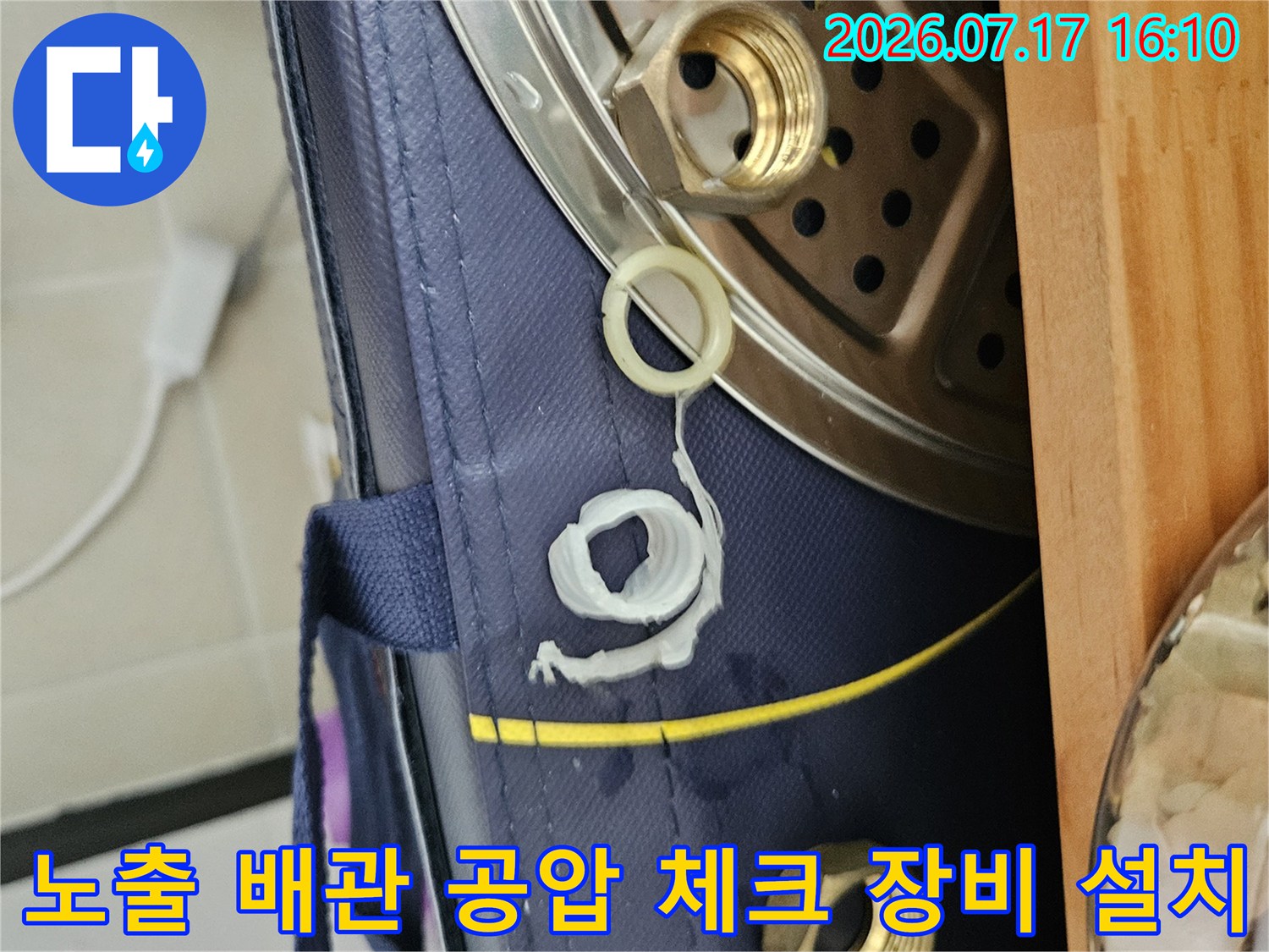 누수 위치를 정확히 찾기 위해 수전 근처 노출 배관에 압력 측정용 호스를 연결한 장면