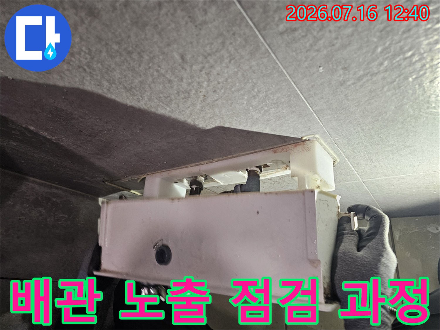 글쓴이가 작업 현장에서 장갑을 끼고 배관 연결부의 상태를 꼼꼼히 살피는 모습