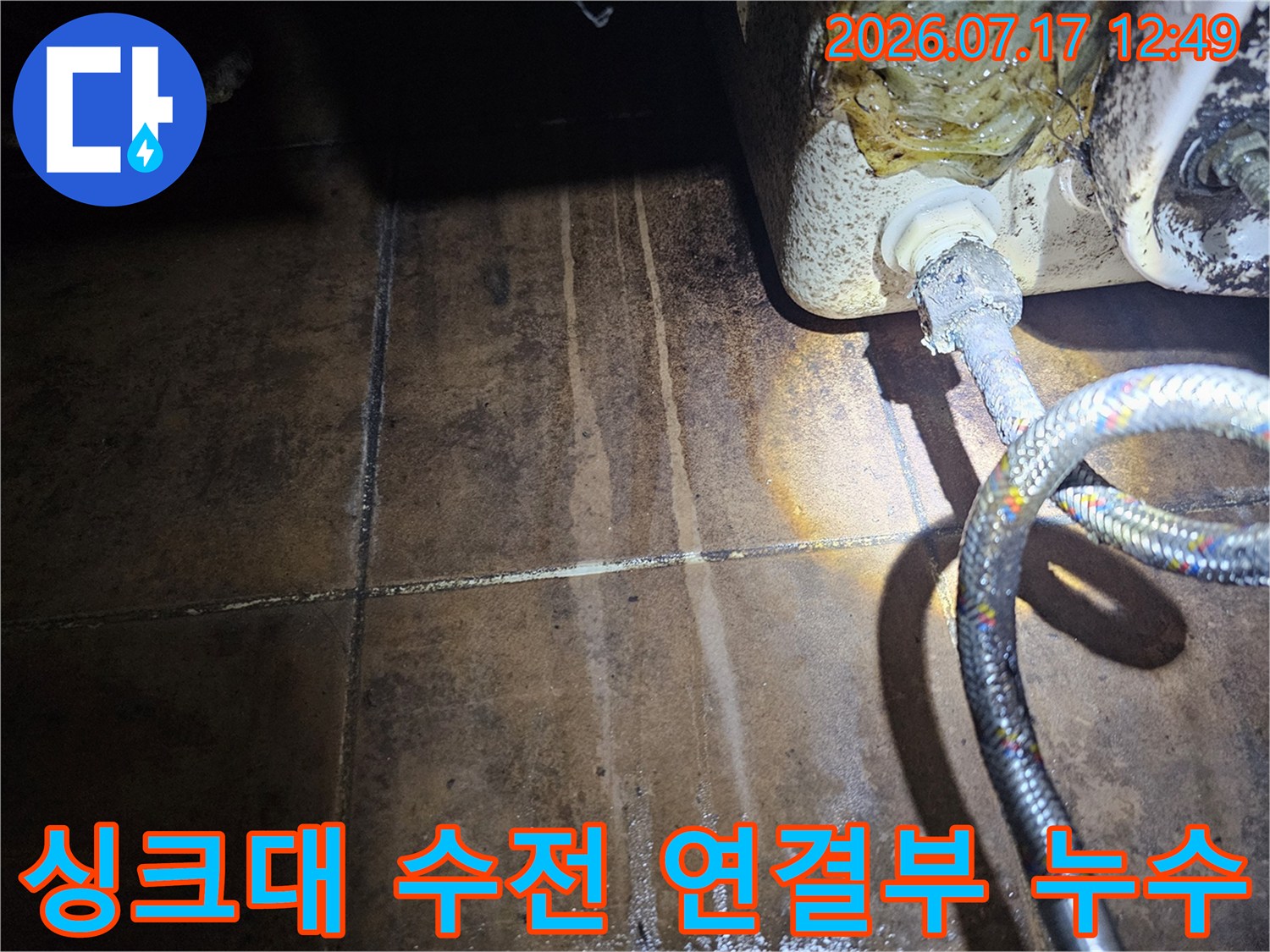 싱크대 하단 수전 연결 부위의 노후된 호스와 배관 연결 상태를 점검하는 모습