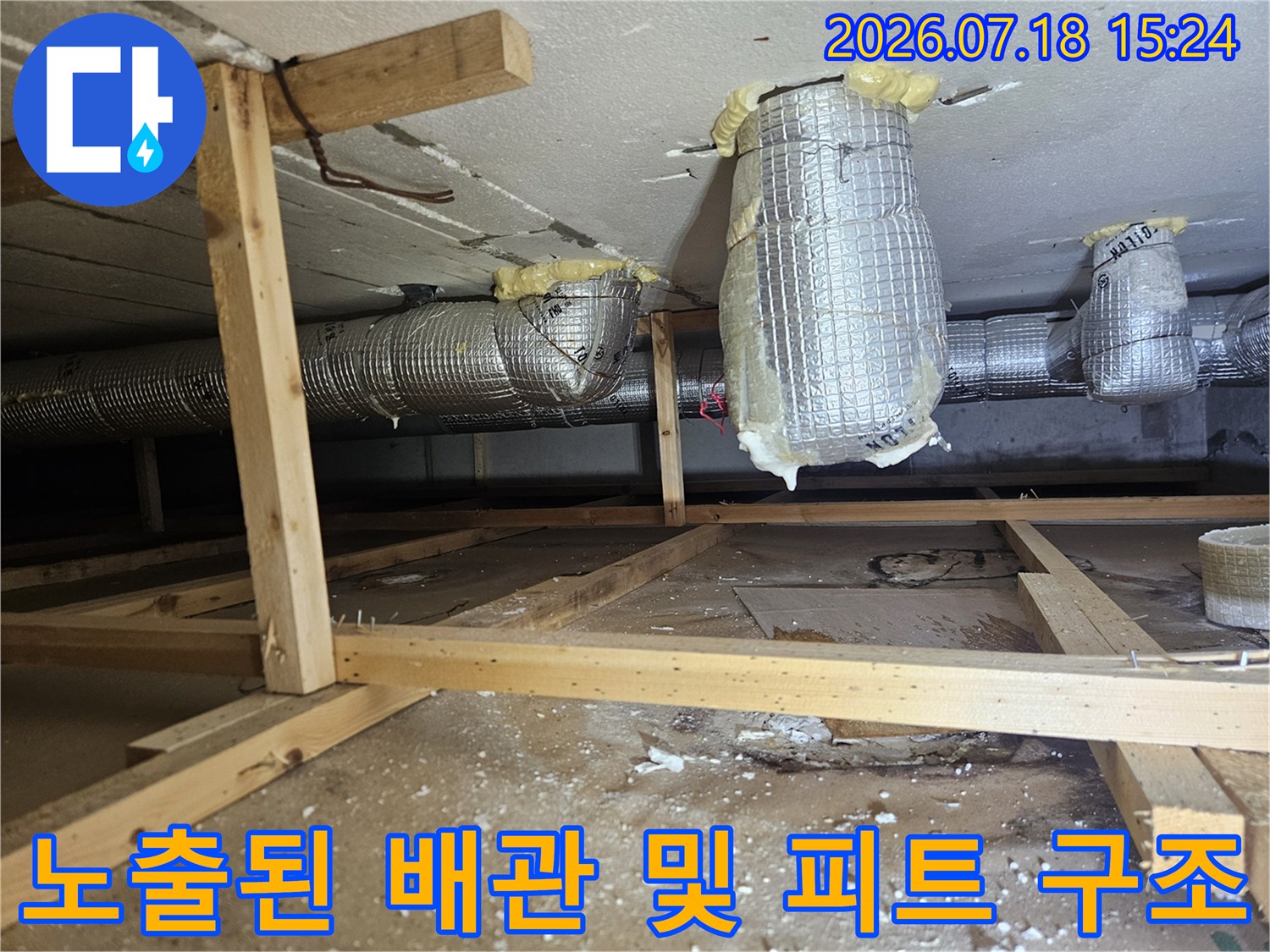 목재 지지대와 보온재로 감싸진 복합 배관 시스템