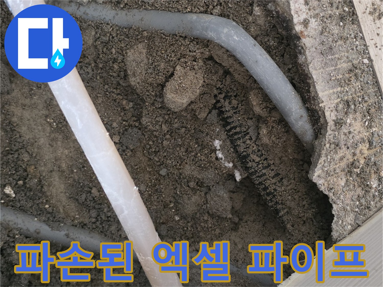 흙 속에 드러난 손상된 회색 배관과 주변 자재