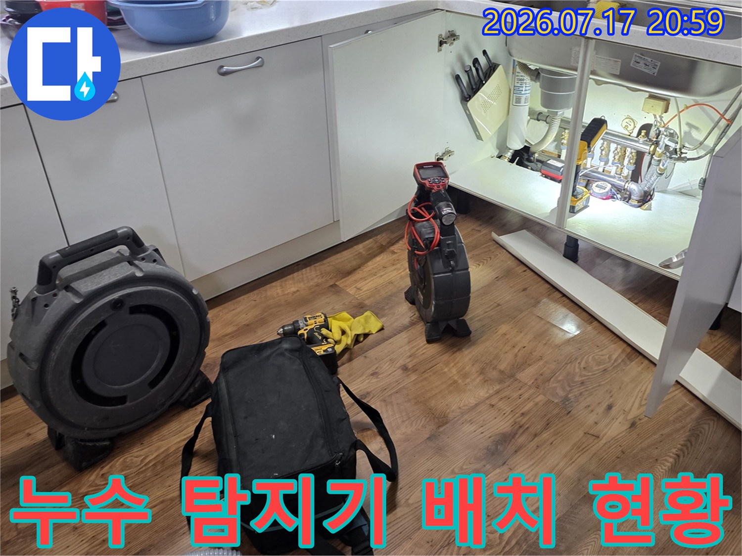 싱크대 하부 공간에 가스 감지기와 청음 장비를 놓고 배출 배관 점검 중인 모습