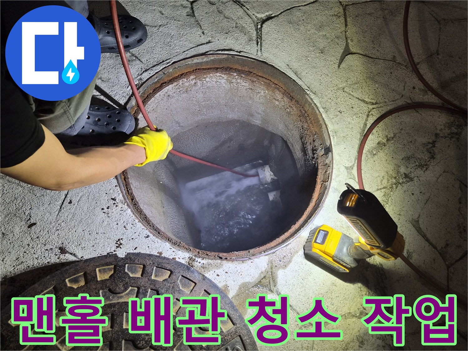 어두운 맨홀 안쪽으로 장비를 투입하여 이물질을 제거하는 과정