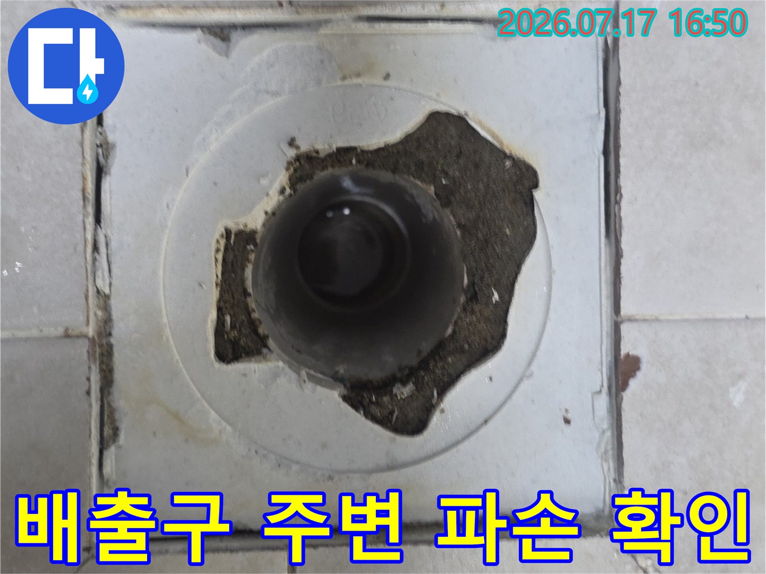 깨지고 훼손된 배수구 주변의 타일 마감재와 노출 배관