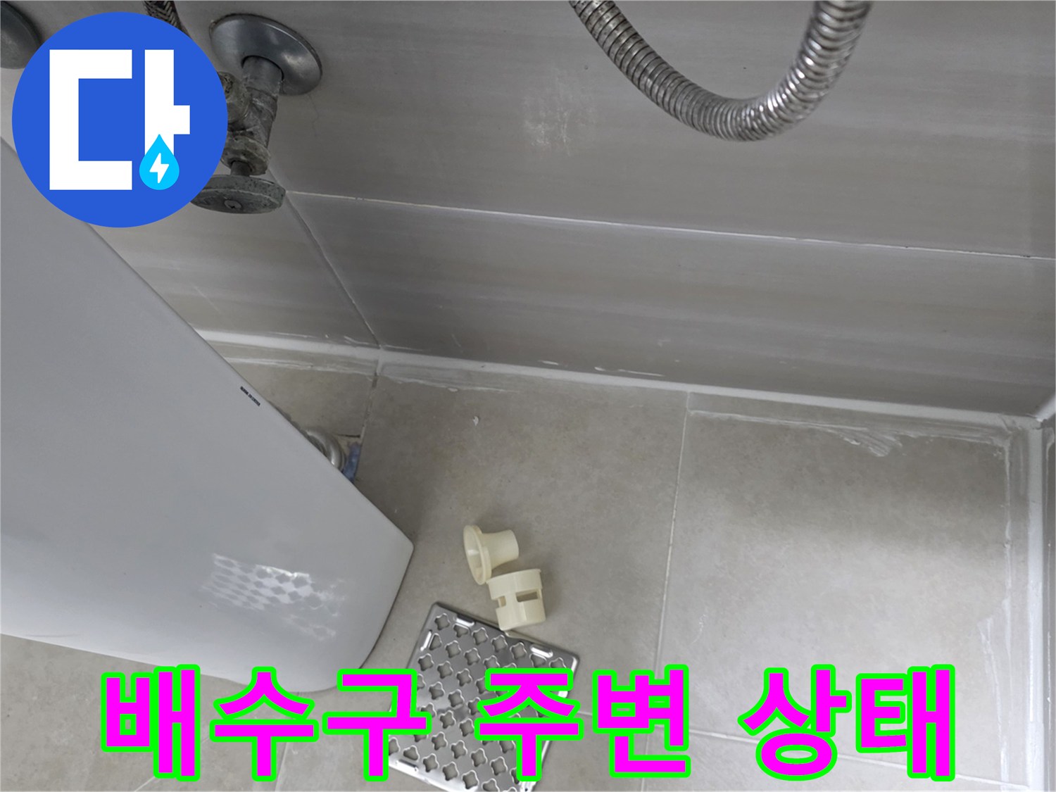 화장실 배수구 유가 주변의 타일 마감과 배관 연결 부위 모습
