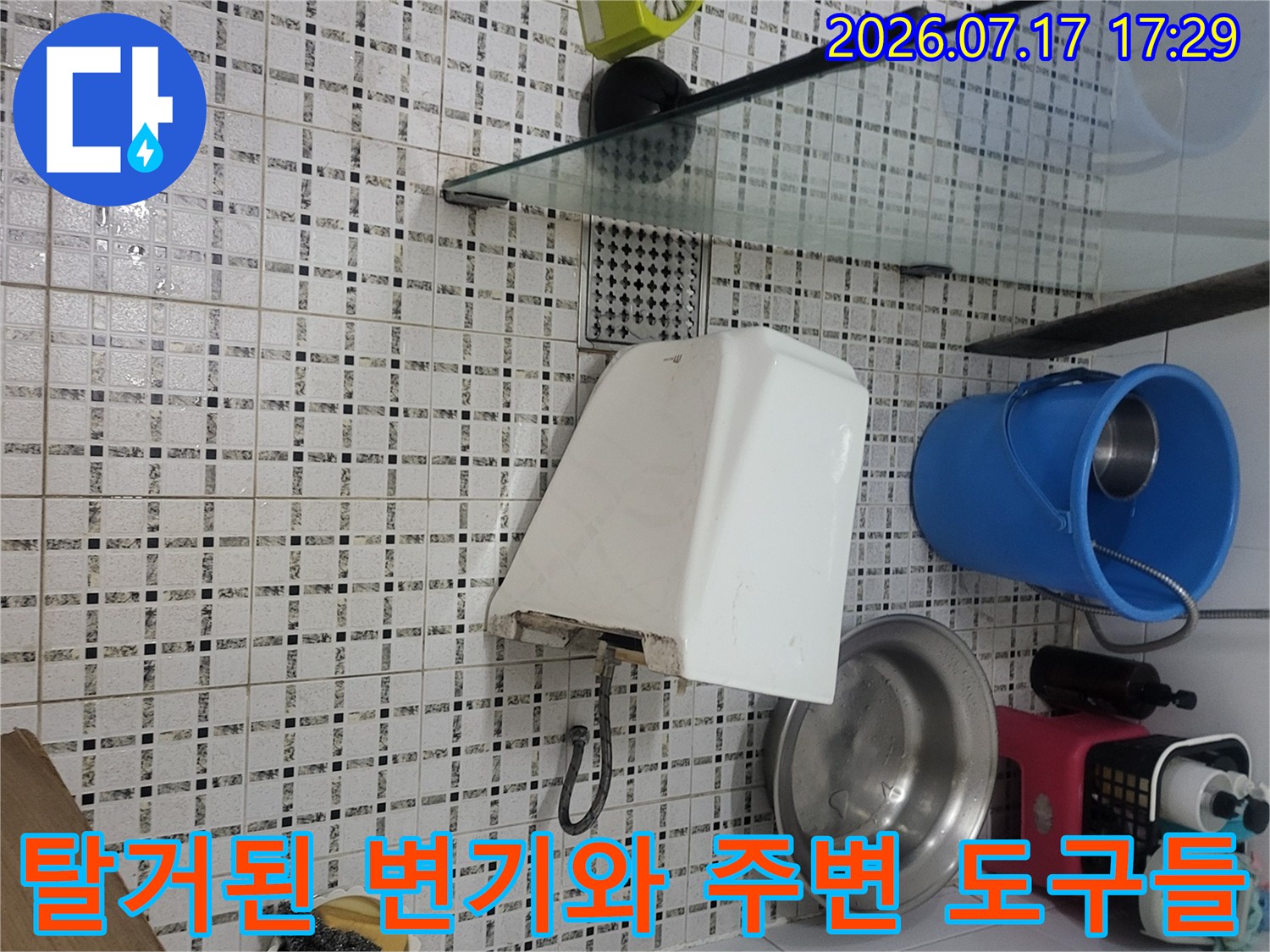 분리되어-옆으로-치워진-흰색-변기와-파란색-플라스틱-버킷이-함께-찍힌-사진