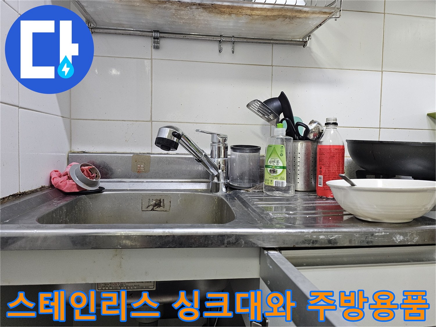싱크대 수전 주변에 놓인 세척 용품과 그릇들