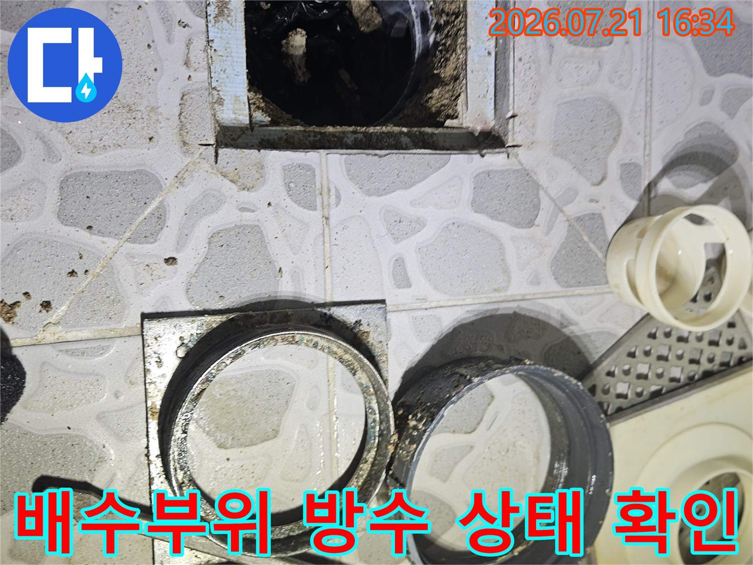 노출된 배수 트럼과 주변 배관 연결 부위의 누수 원인을 분석하는 현장 사진