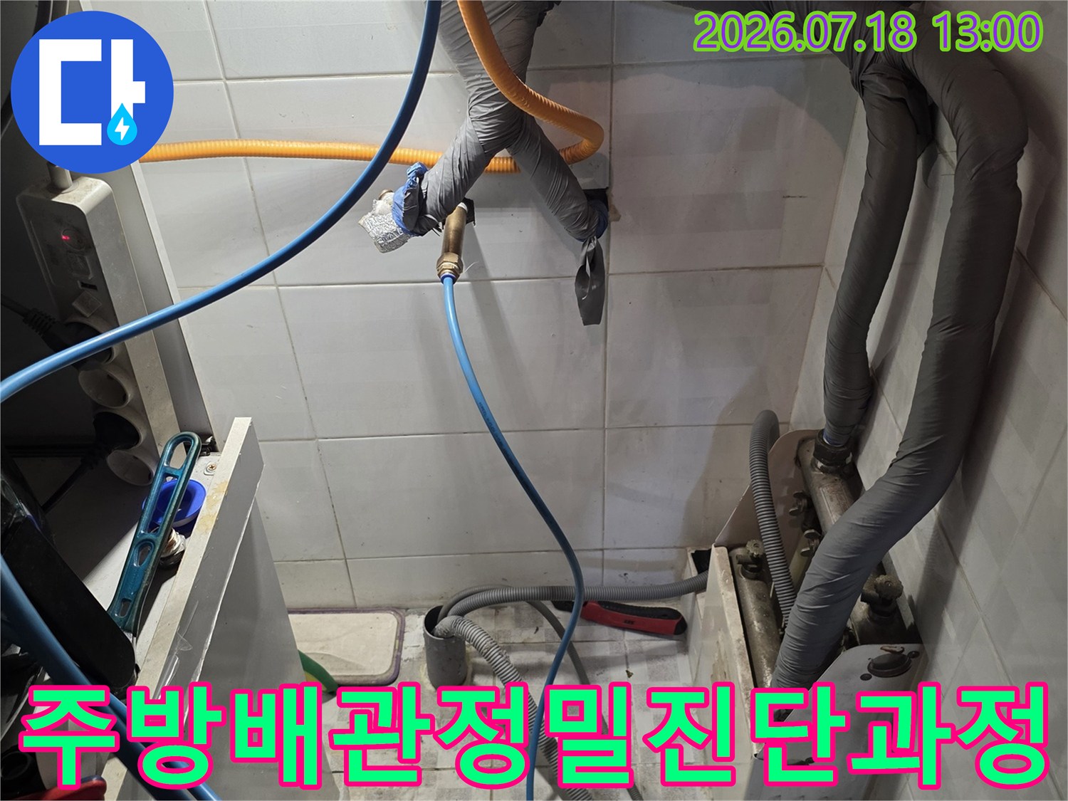 회색 보온재가 덮인 벽면 배관에 파란색과 노란색 측정 호스가 연결된 사진