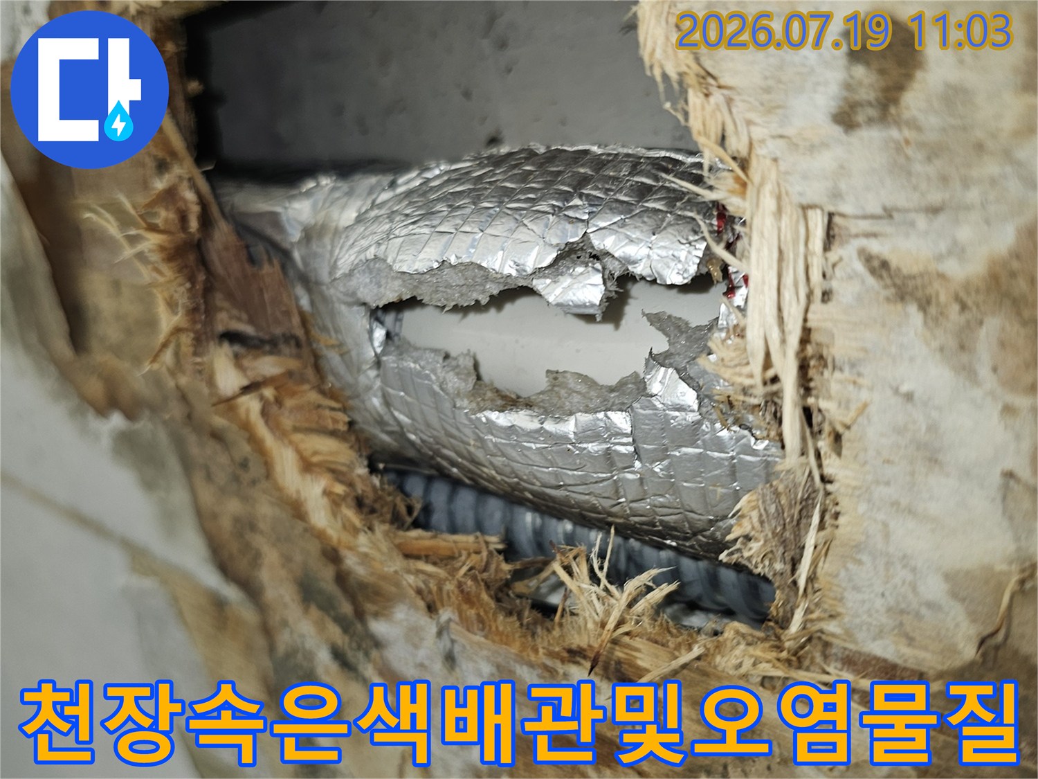 습기로 인해 부식된 천장 자재와 은색 단열재가 감싸진 드레인 배관의 모습