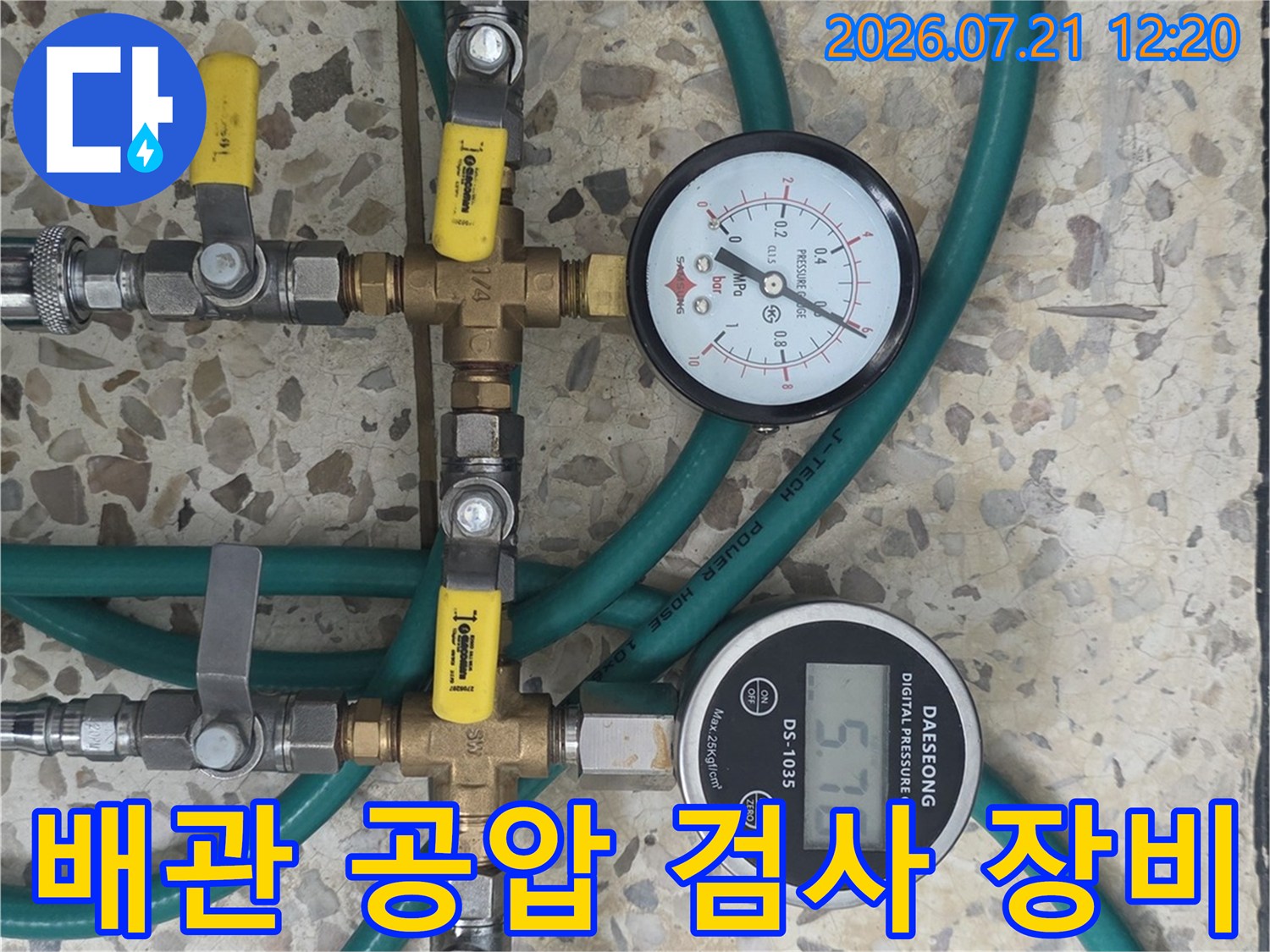 두 개의 압력계가 설치된 배관 공압 테스트 시스템과 호스 연결부