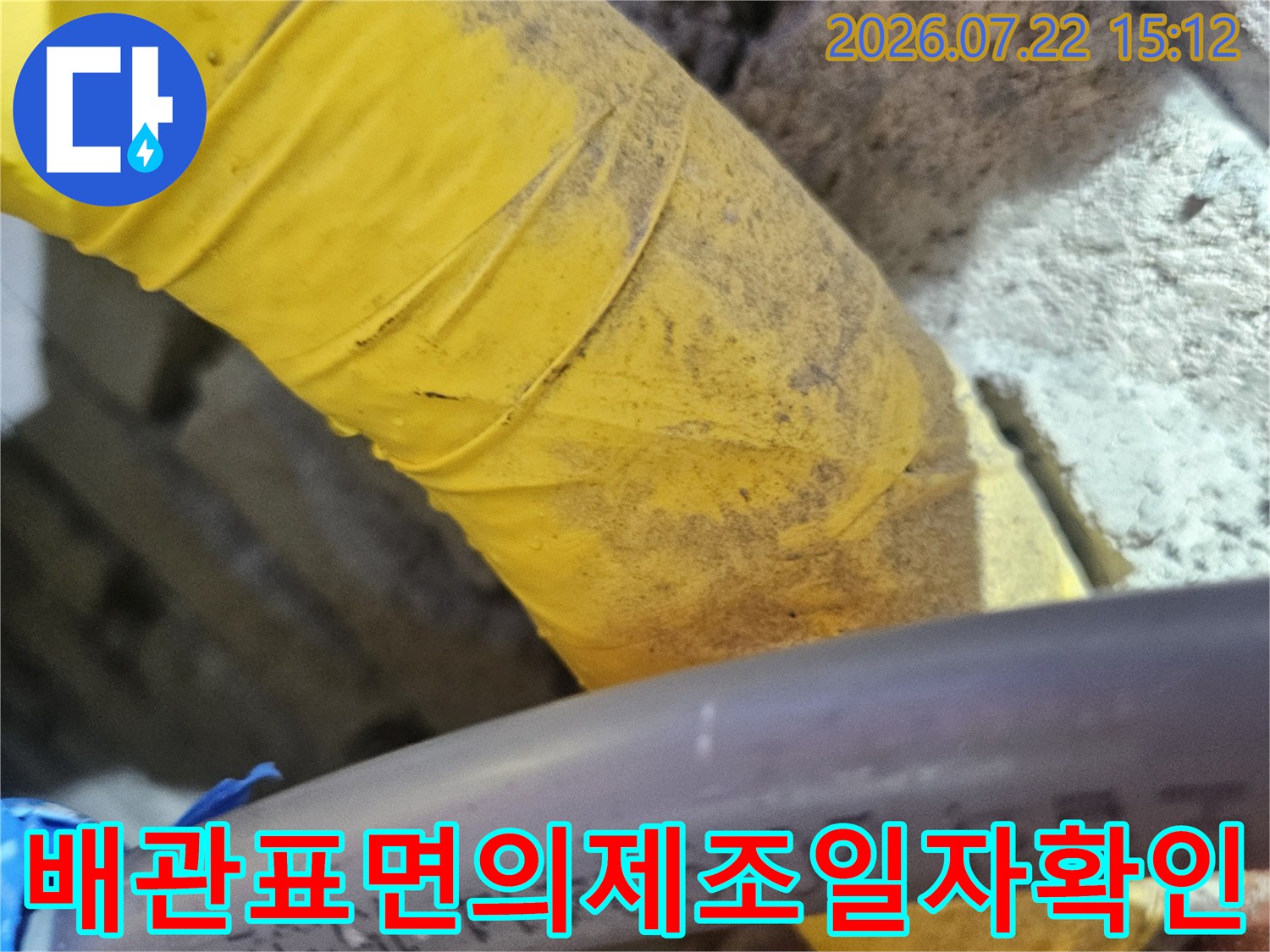 회색 배관 표면에 인쇄된 숫자와 문구-노란색 단열재가 함께 배치된 장면