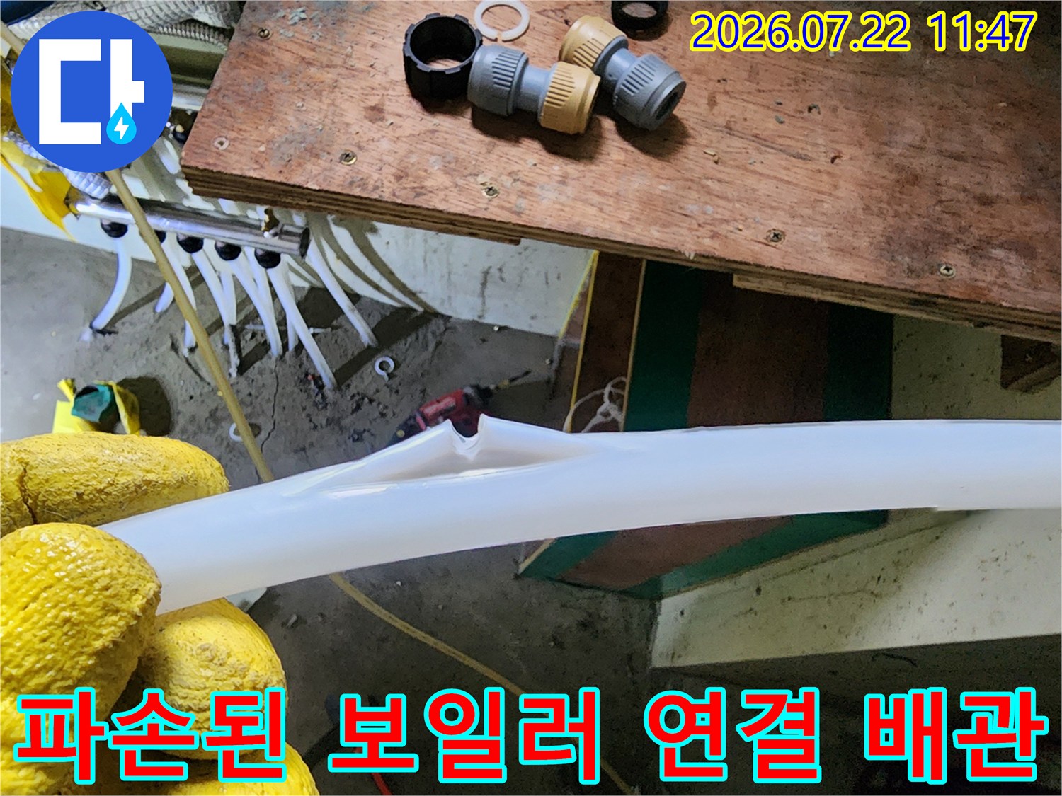흰색 플라스틱 소재의 PEX 배관이 갈라지고 찢어져 내부가 드러난 파손 부위 사진