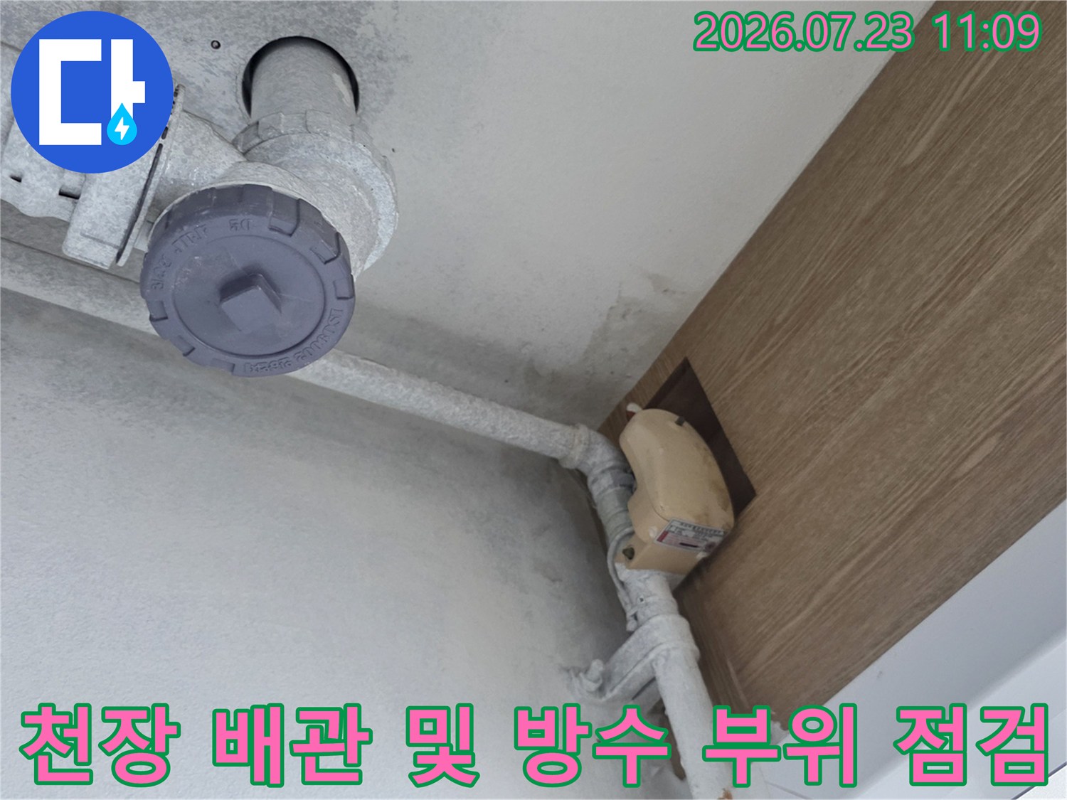아파트 천장에 설치된 회색 배관과 갈색 마감재 사이의 누수 의심 부위-사진