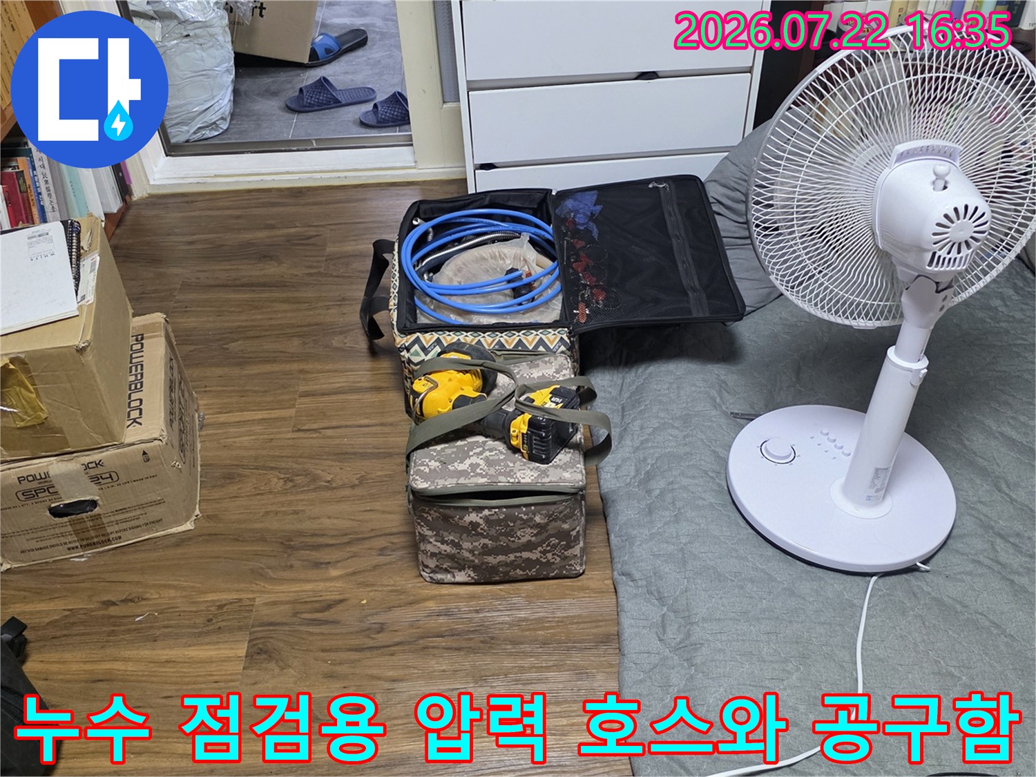 바닥에 펼쳐진 누수 탐지 장비와 파란색 배관 테스트 호스-작업 시작 전 준비 단계