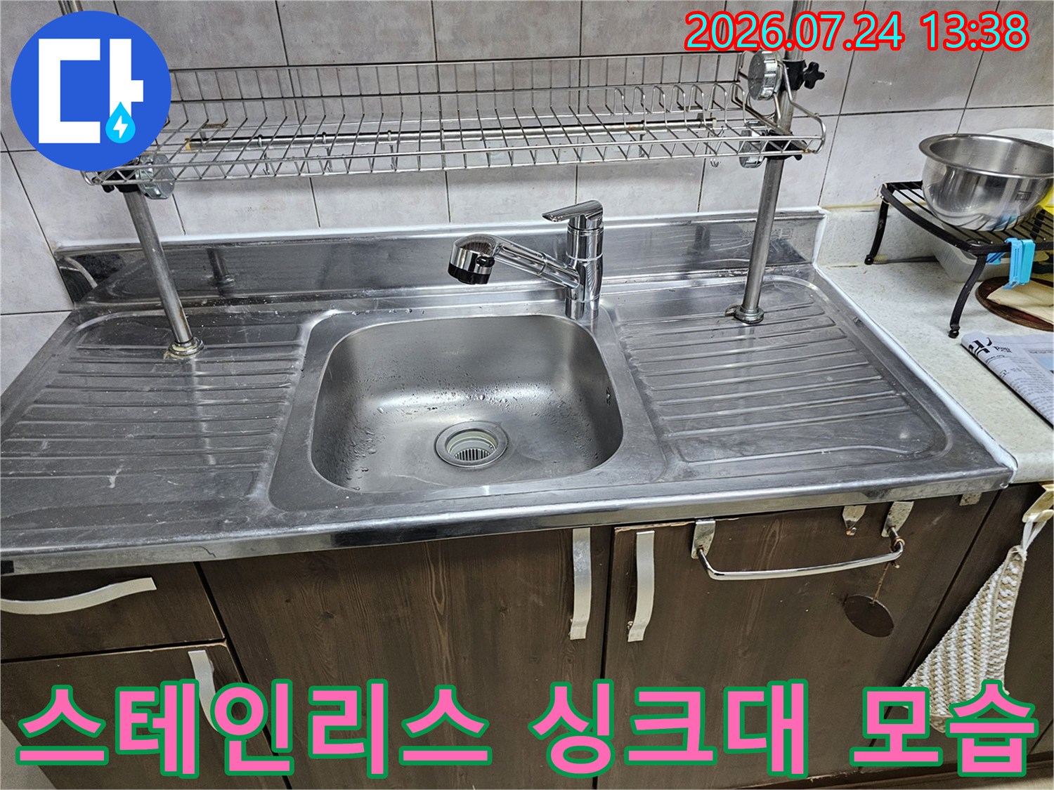 싱크볼과 수전-금속제 선반이 설치된 주방의 전형적인 싱크대 모습