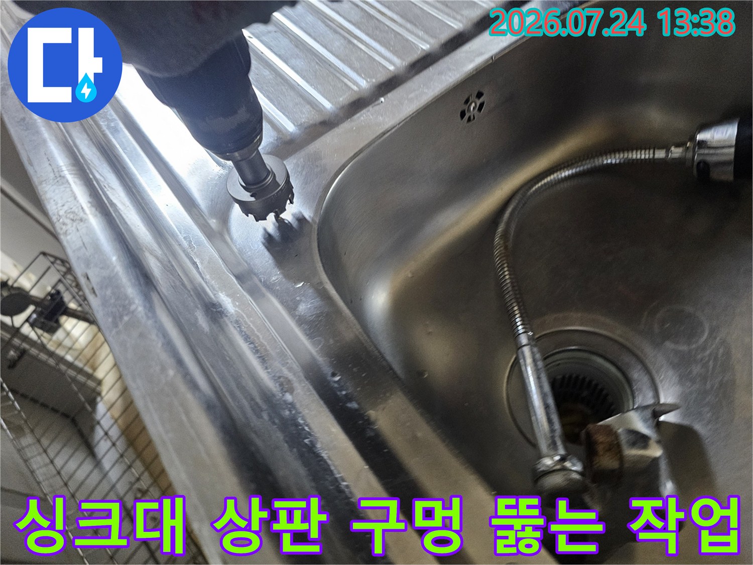 전동 드릴을 사용하여 싱크대의 스테인리스 부분을 타공하고 있는 엔지니어의 손과 장비