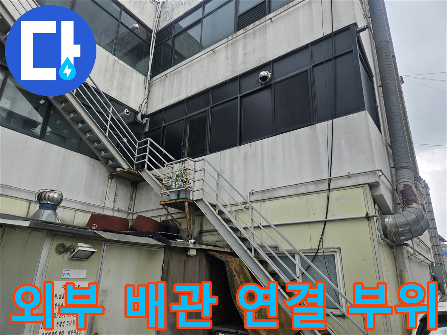 상가 건물 외벽에 설치된 금속 구조물과 외부 배관 촬영