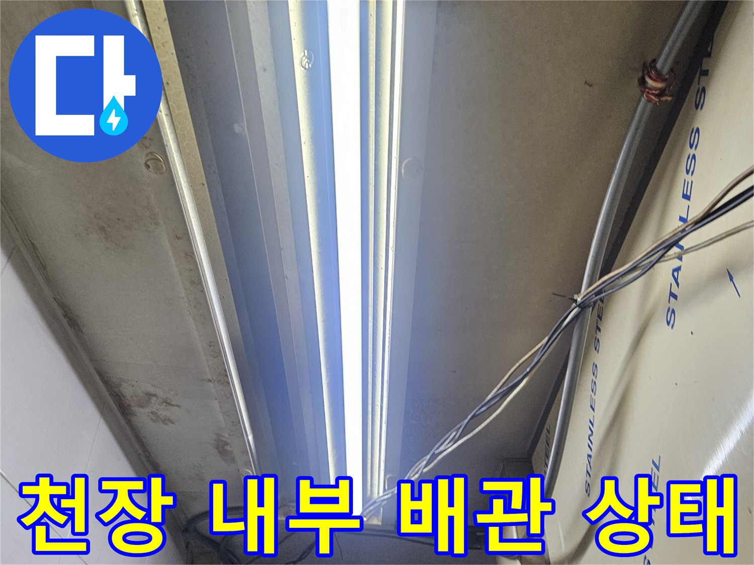 스테인리스 판넬로 덮인 천장 구조물과 노출된 전선 및 배관의 모습입니다.