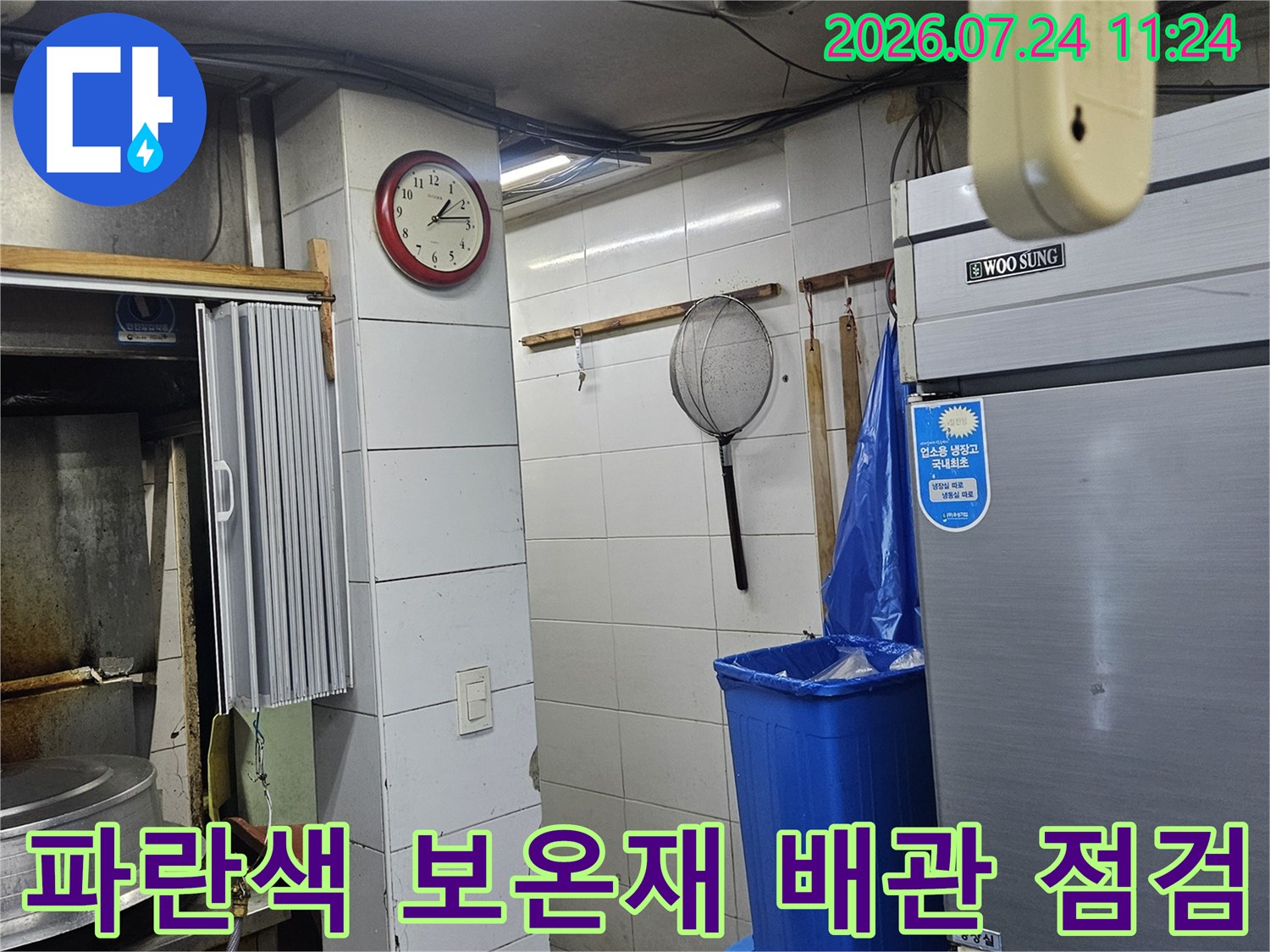 파란색 단열재로 마감된 온수 공급 배관과 주변 벽면 구조물