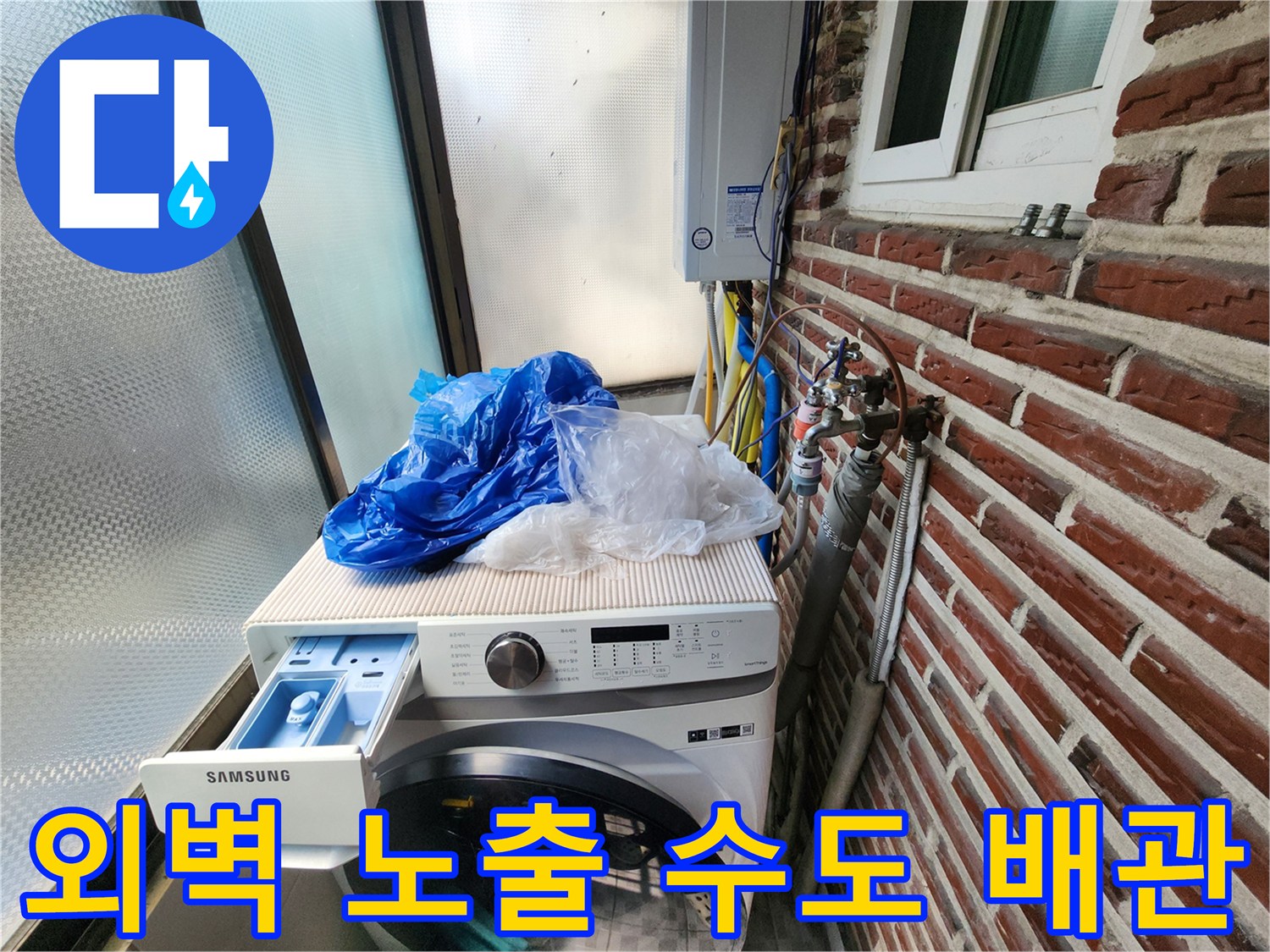 벽돌 벽면에 설치된 외부 노출형 수도 계량기와 연결 배관