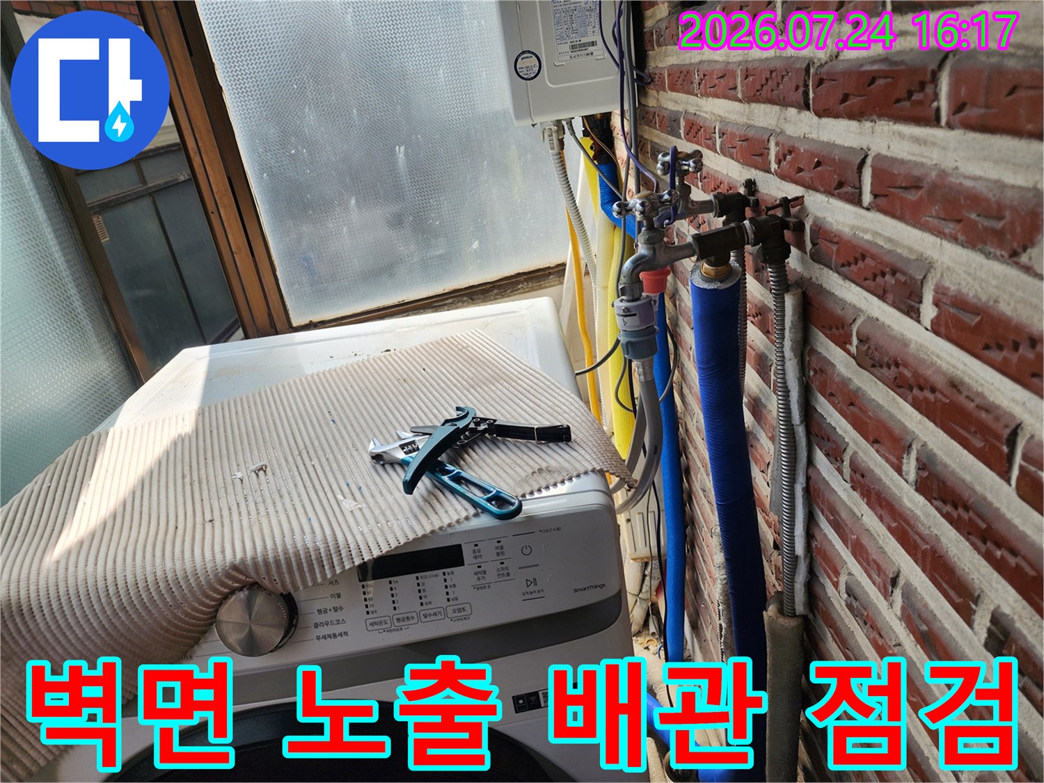 세탁실 옆 벽돌 벽면에 설치된 수도 밸브와 파란색 단열재 배관 확인