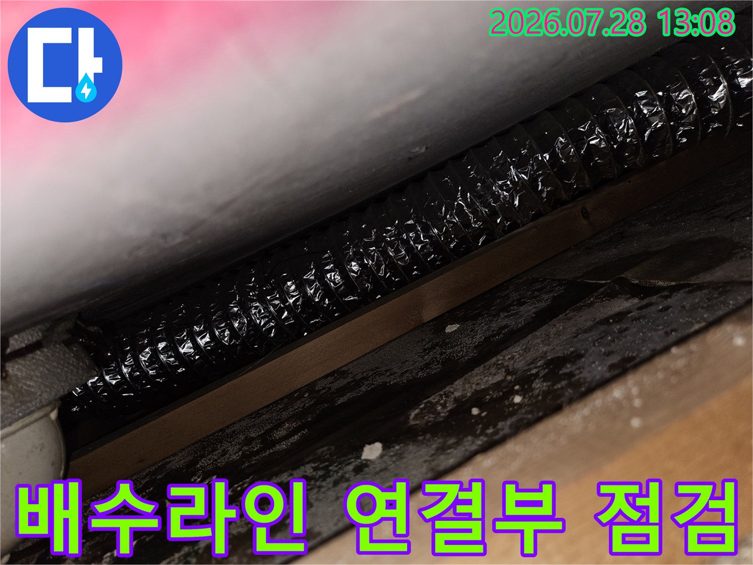 싱크대 하단의 배수용 주름 호스 및 결합 부위 상세 사진