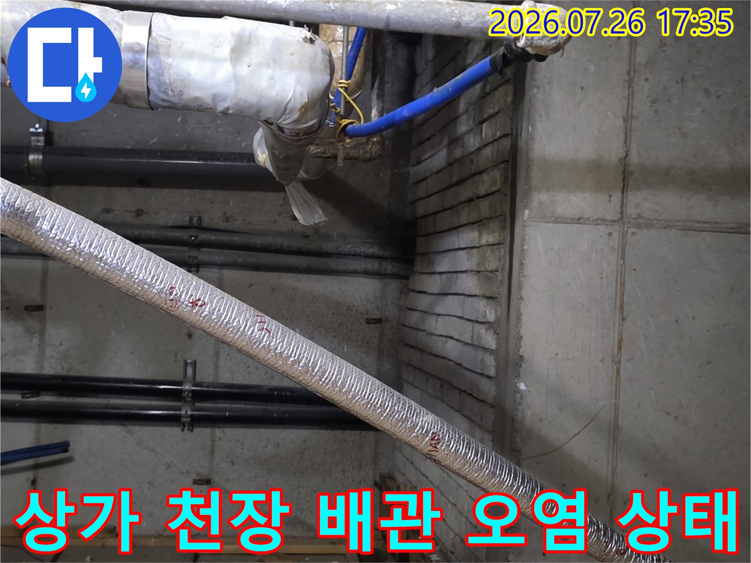 상가 건물 내부-천장 슬래브와 복잡하게 얽힌 배관들의 누수 흔적 사진