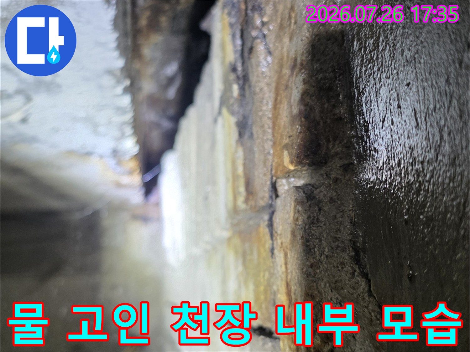 어둡고 좁은 천장 공간의 콘크리트 바닥면에 물이 고여 있고 변색된 장면-누수 진단 사진