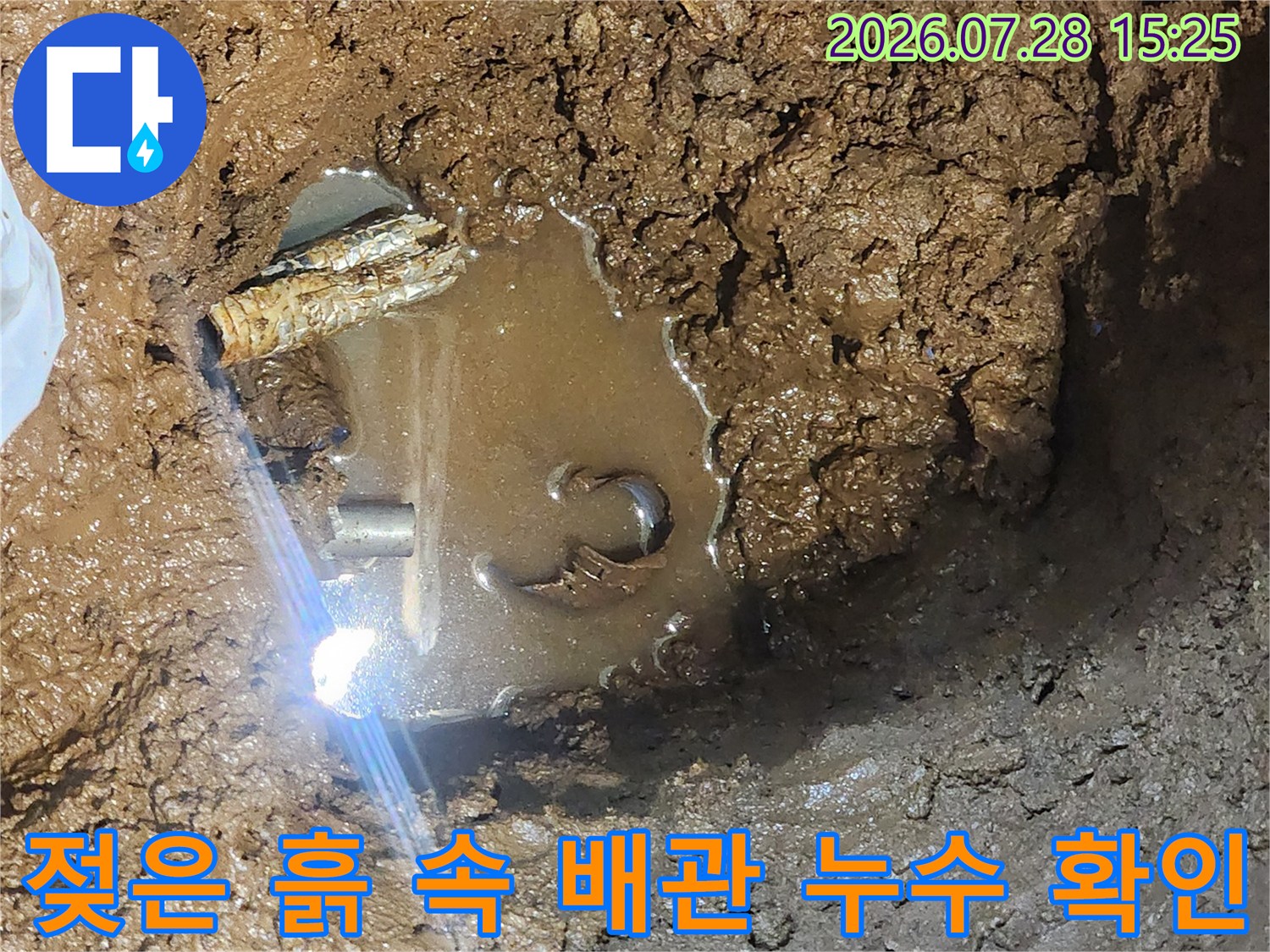 물에 젖은 토양과 파손된 구간의 배관이 노출된 장면