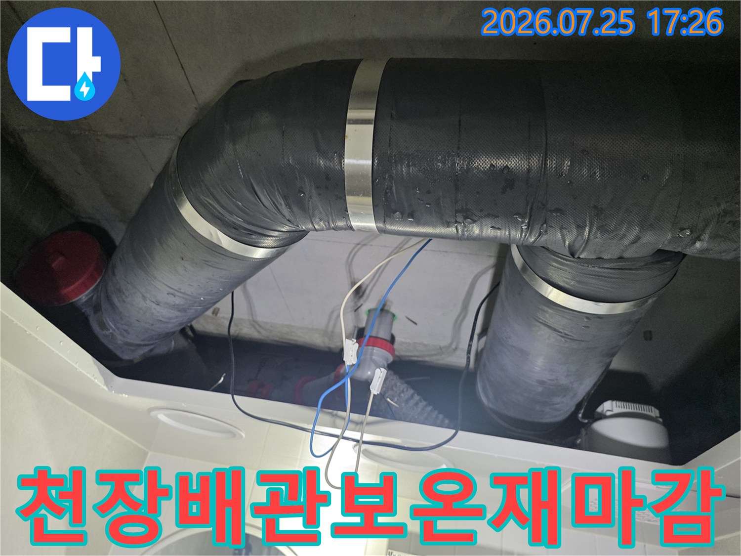 검은색 보온재로 감싸진 화장실 천장 배관과 수선된 연결 부위