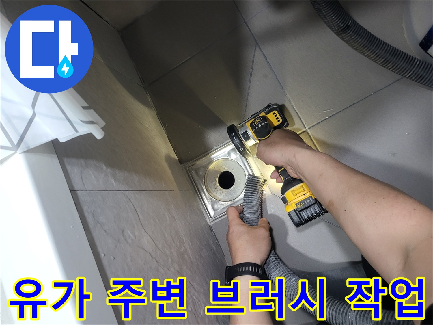 전동 공구를 사용하여 배수구 유가 부근을 세척하는 장면입니다.