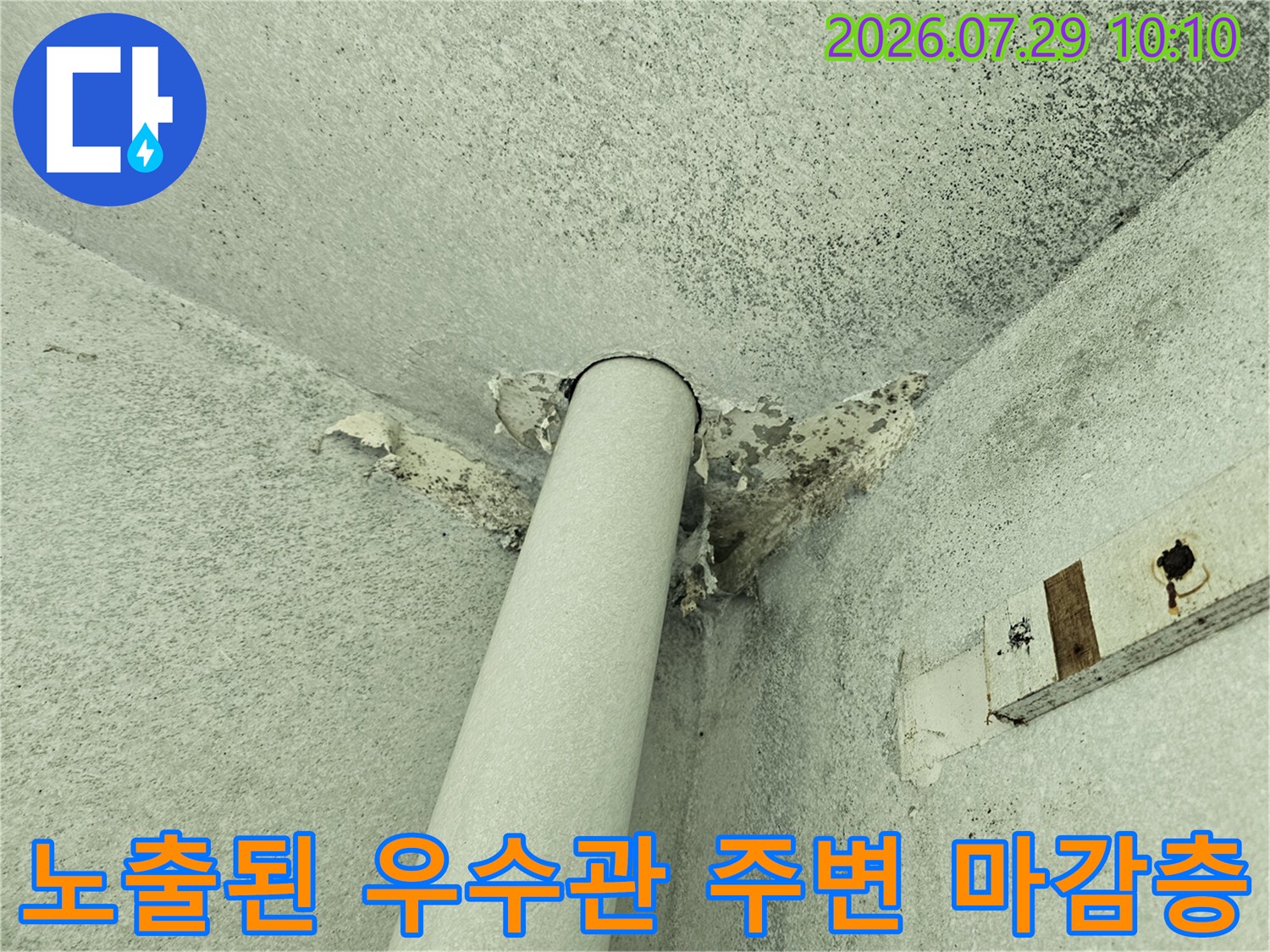 우수관과 천장이 만나는 부위에 노출된 파손된 마감재