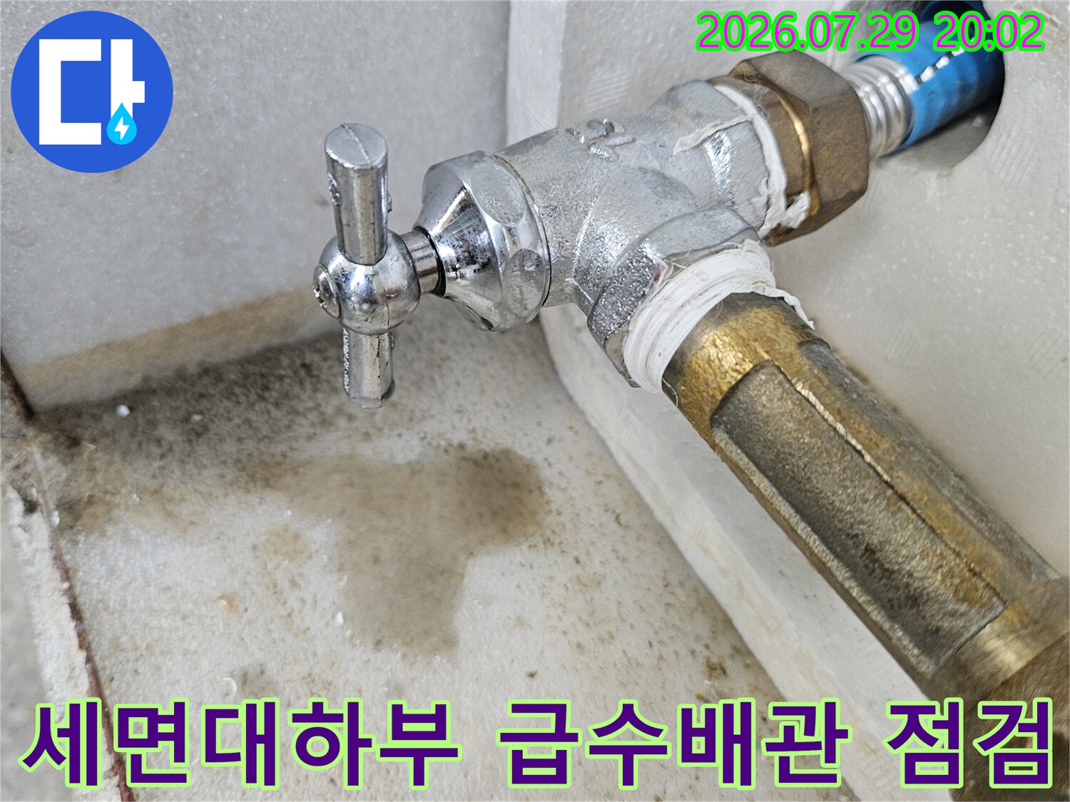 세면대 하단부에 위치한 금속 소재의 급수 밸브와 노출된 배관 연결 부위