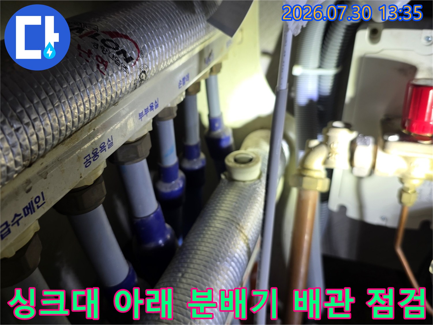 싱크대 하부장 내부에 위치한 온수 및 냉수 배관 분배기 모습
