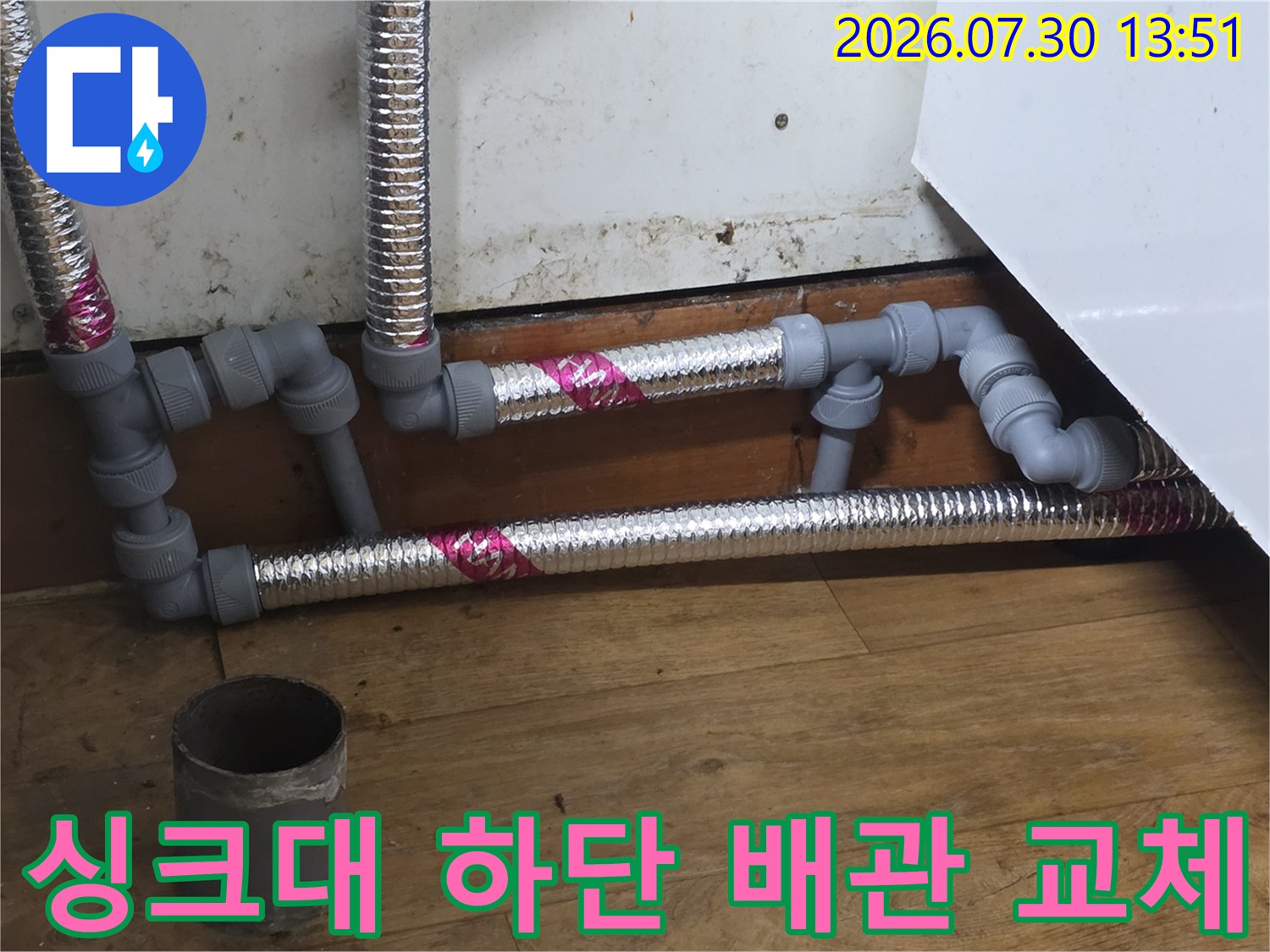 스테인리스 주름관과 파이프 부속으로 교체된 싱크대 하부 배관 모습