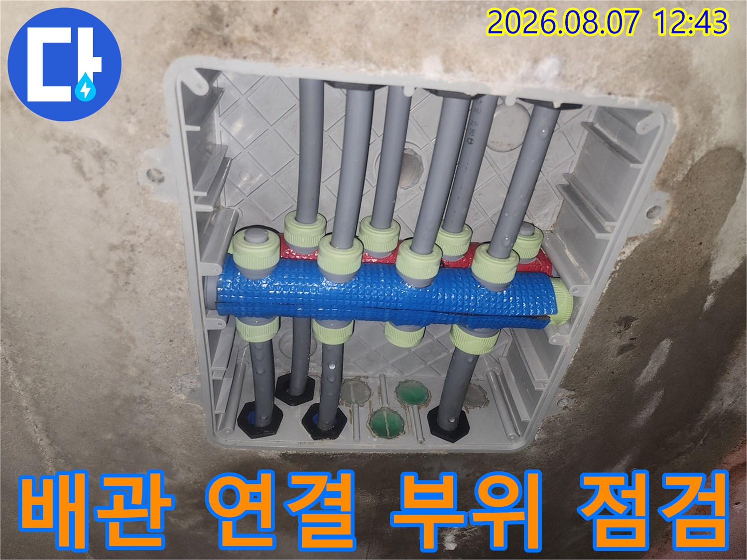 파란색과 초록색 부속이 사용된 배관 분기 지점의 사진입니다.