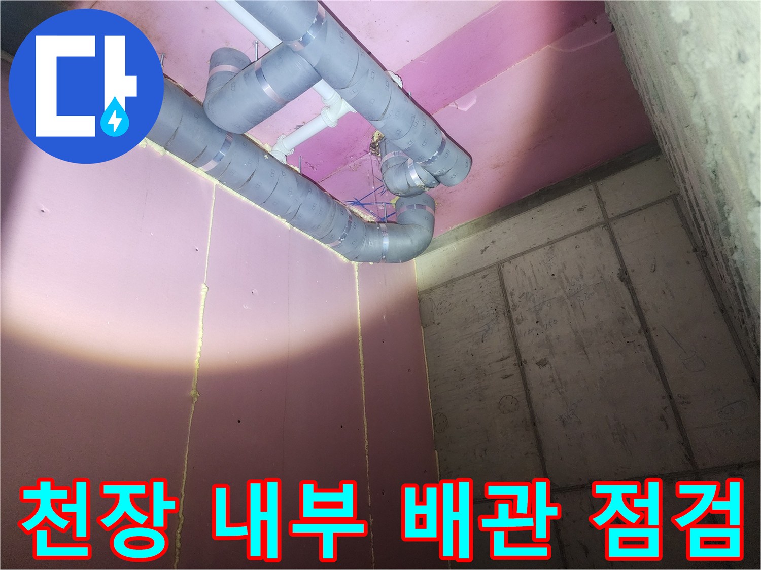 분홍색 천장 구조-회색 PVC 배관의 연결 부위 정밀 검사 중