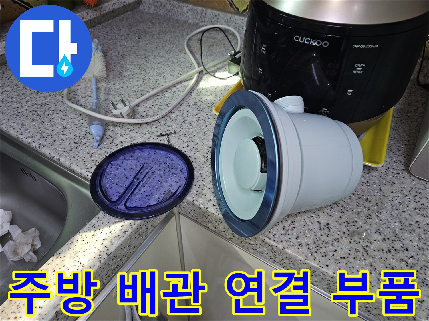 싱크대 하단 작업 공간에 놓여 있는 배관 소모품 세트
