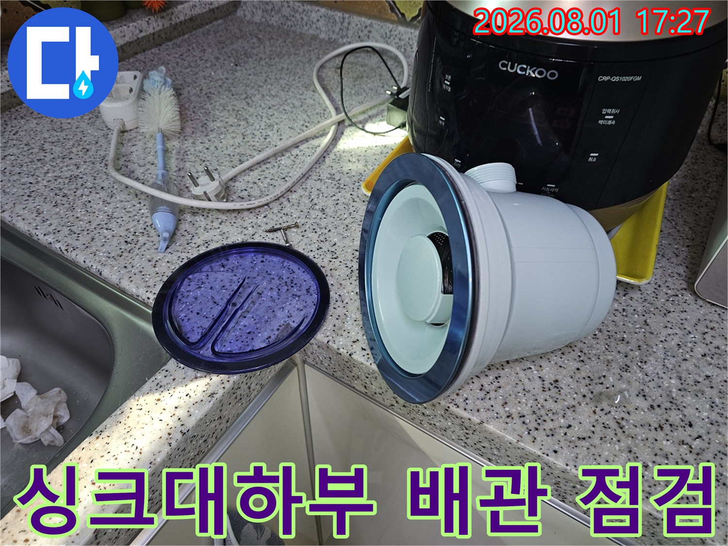 싱크대 하부 공간에서 노출된 굴곡진 배관과 가전제품 주변의 정밀 점검 현장