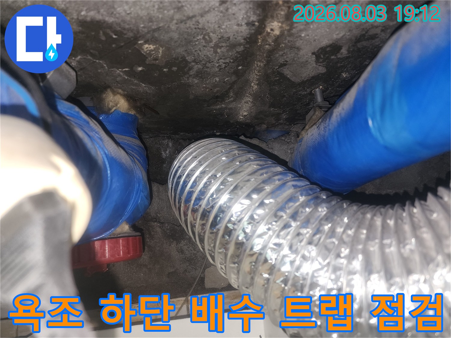 은색 주름형 배관과 파란색 보호재가 적용된 욕조 하부 배수 라인