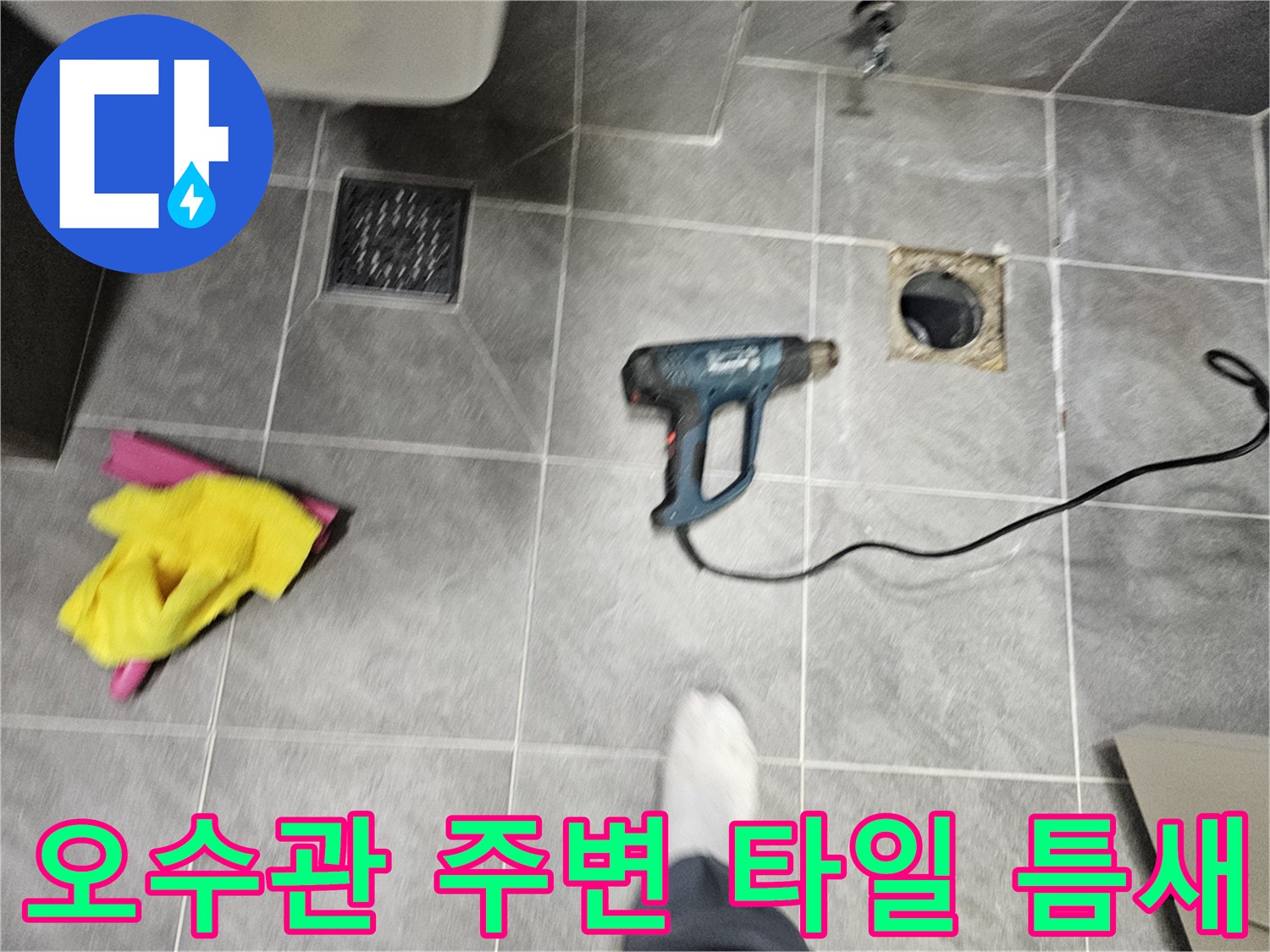 배수관 주변의 노출된 타일과 작업 도구 배치