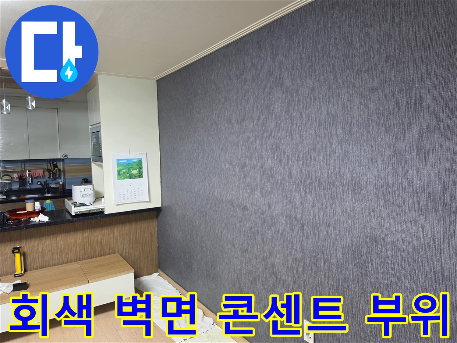 벽면 하단 콘센트와 회색 도배지의 근접 촬영