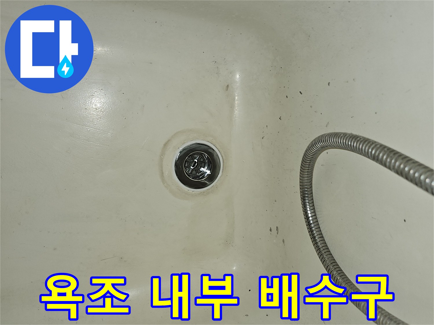 금속 소재의 샤워기 호스와 흰색 욕조 배수구 부위