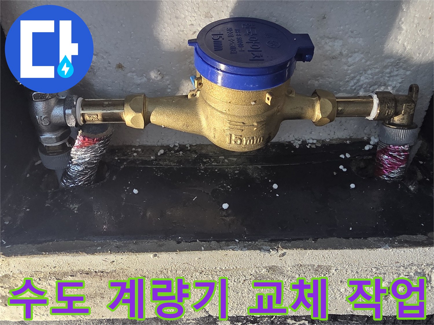 축축하게 젖은 수도 계량기함 내부의 배관 보수 공사 현장입니다.