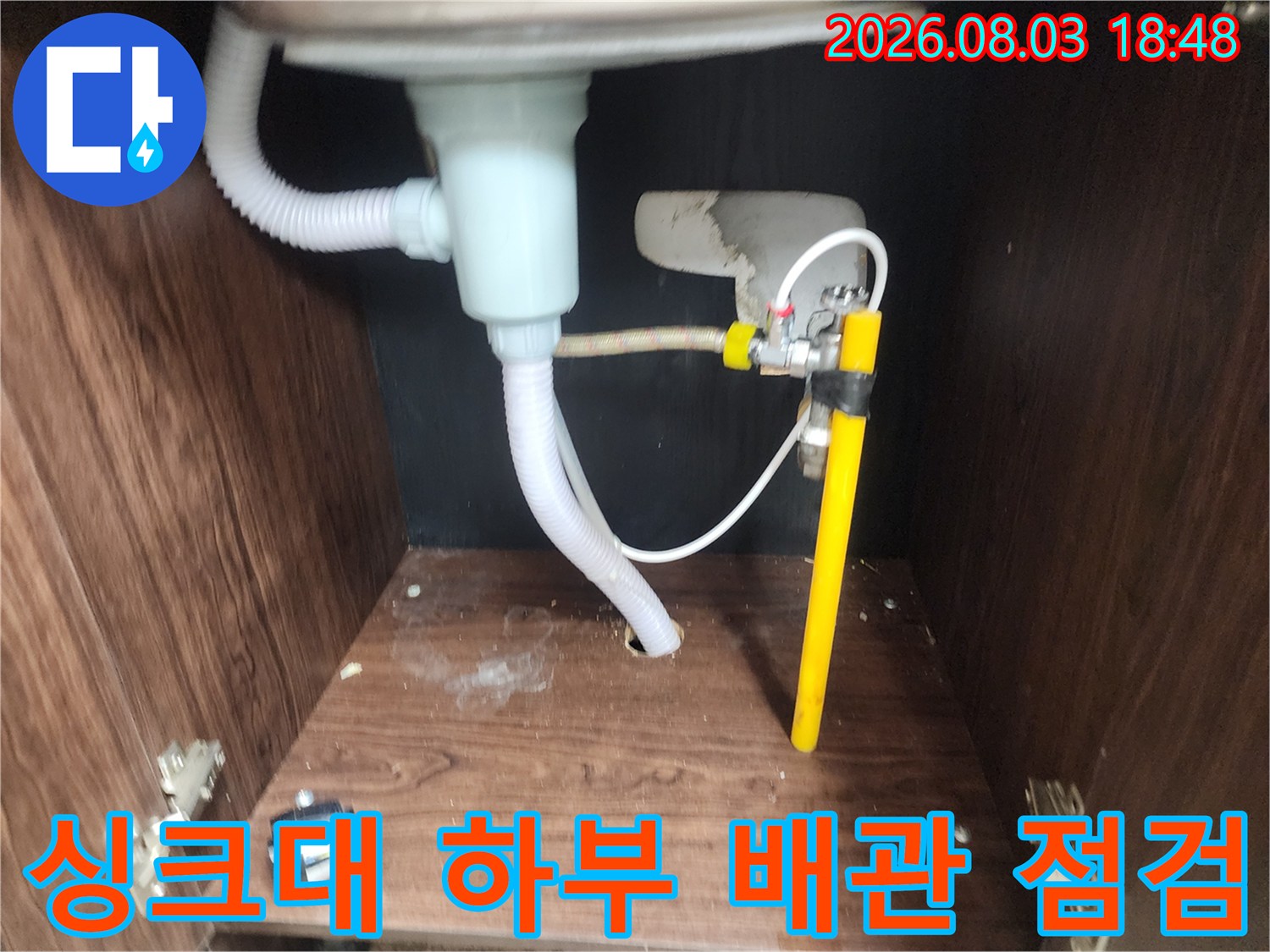 싱크대 하단부의 노란색 배관과 유연한 호스 연결 부위 상세 점검