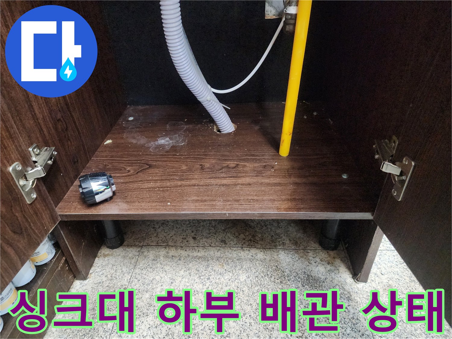 천안 동남구 현장의 싱크대 하부장 내부 배수 호스와 벽면 관통 부위 모습