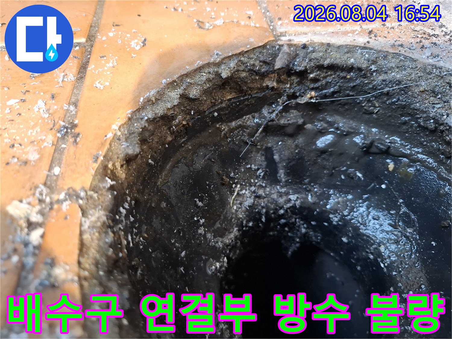 거칠게 노출된 배수구 주변의 파손된 마감재와 내부 통로 모습