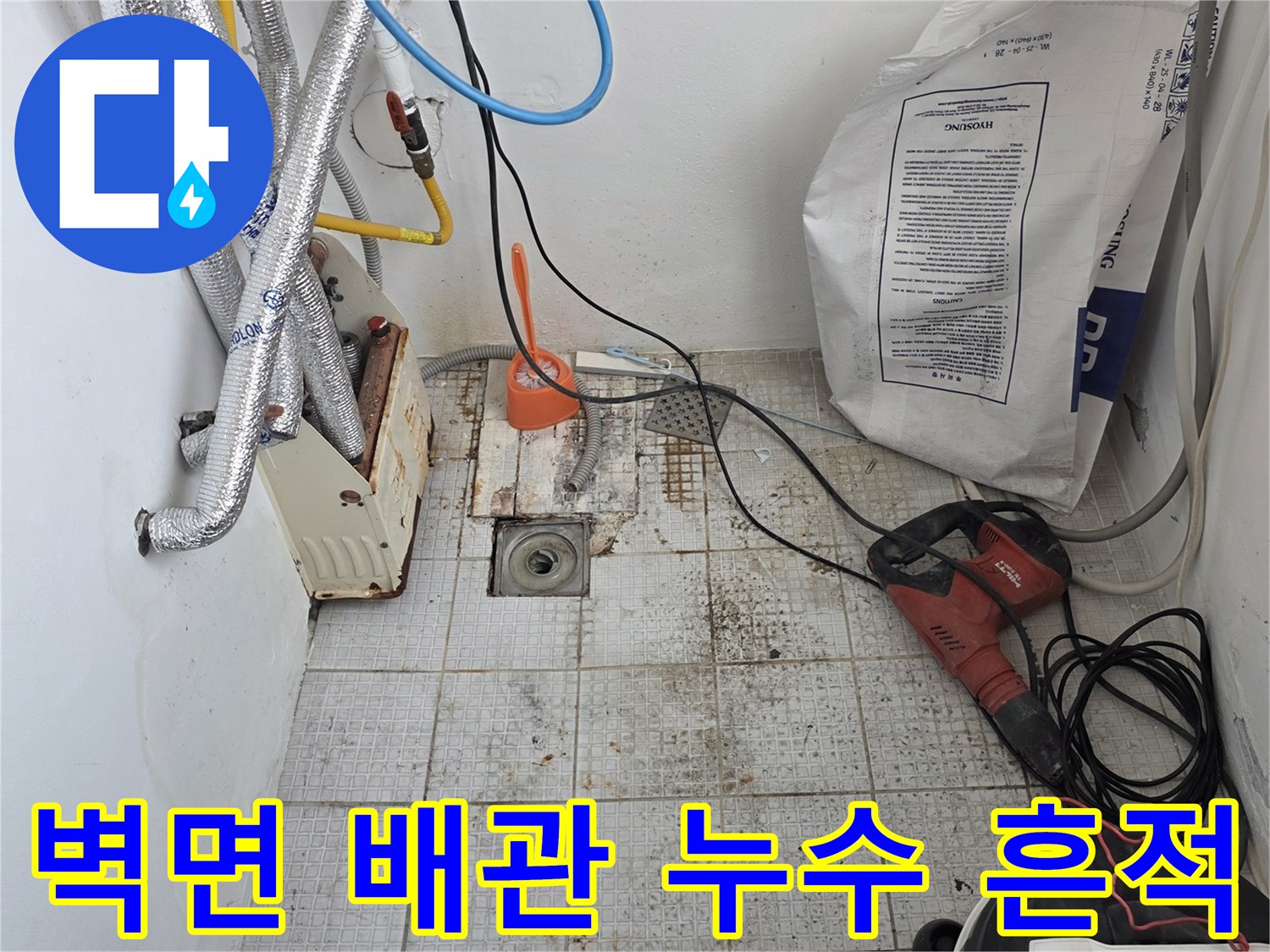 세탁실 벽면의 배관 보온재와 오염된 타일 부위를 근접 촬영한 사진입니다.